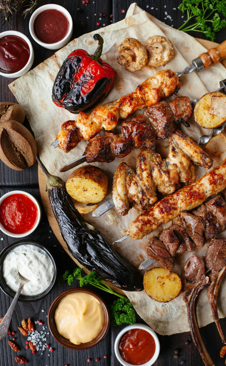 Nahaufnahme einer Kohlmeise, die auf einem moosbedeckten Ast in einer ruhigen Waldlandschaft sitzt.